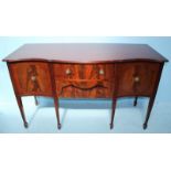 An Edwardian mahogany serpentine fronted sideboard, with central drawer above another drawer,
