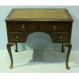 A 20th century mahogany knee hole writing desk, with inset leather scribe, above two short frieze
