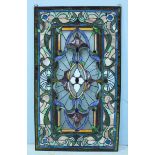 A stained glass window in stylized foliate design