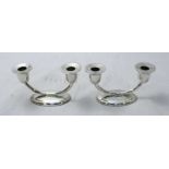 A pair of .900 grade silver two light candelabra, raised on oval bases. Gross weight approximately