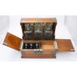 A Victorian oak Tantalus and games compendium, the case with brass strap work and housing three