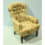 A Victorian 'style' button-back armchair with pink, green and beige floral upholstery, raised on