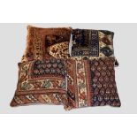 Four small cushions, made up from rug fragments, each 15in., 38cm. Square comprising one