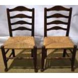 A pair of early nineteenth century Yorkshire ladderback side chairs, in ash and fruitwood, with rush