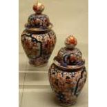 A pair of nineteenth century Japanese porcelain Imari vases and covers, the ribbed bodies with