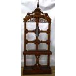 A Victorian oak hall stand, the back with a spire urn finial to the crest, above rosettes and