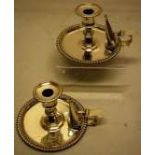 A pair of George IV silver bedroom candlesticks, with gadroon borders, the candleholders with