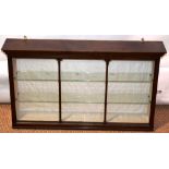 A mahogany hanging display cabinet, the key cornice above glass shelves, enclosed by a glazed carved