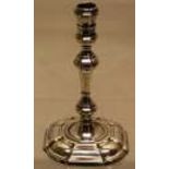 A George II cast silver taperstick, the baluster stem on a welled panelled square base, 4.25in (