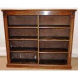 A Victorian mahogany double open bookcase, the moulded edge above shelves with a central division,