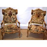 A pair of French winged fauteuils, with carved giltwood frames, upholstered distressed floral