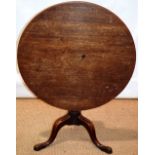 A mid eighteenth century mahogany occasional table, the circular tilt top on a plain turned stem (an
