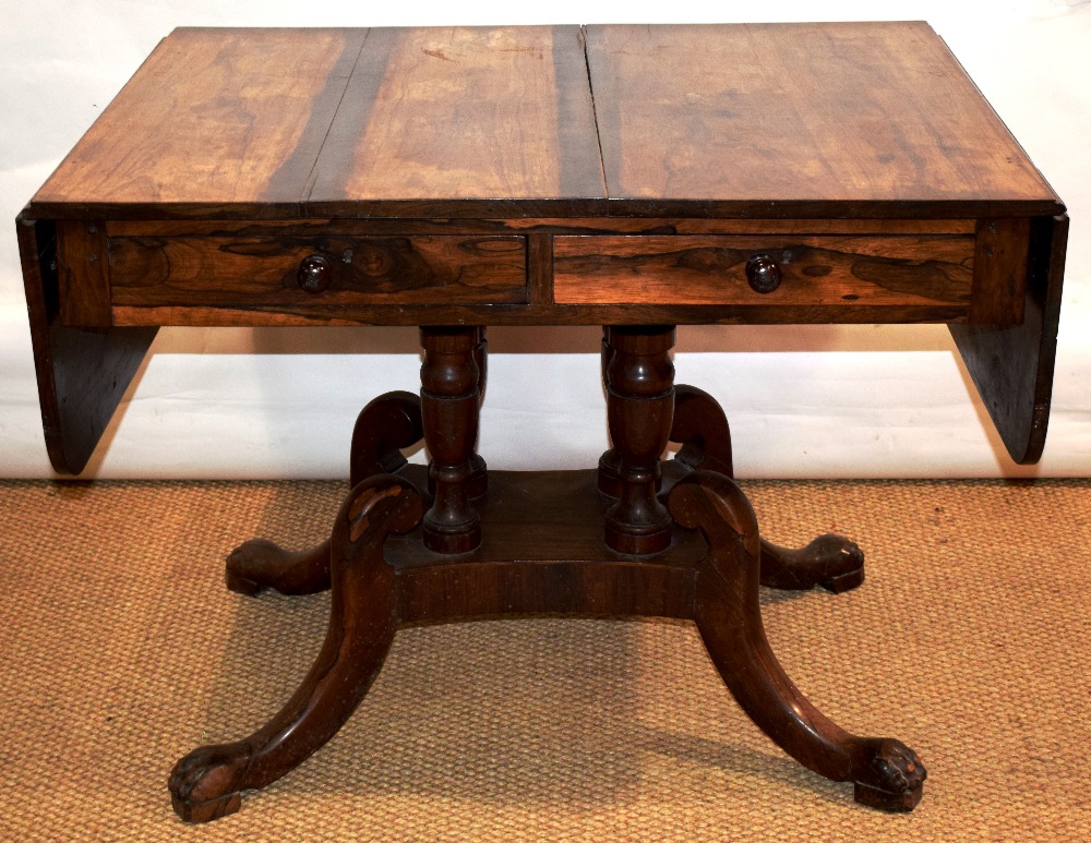 A George IV rosewood veneered sofa table, the drop leaf top above two frieze drawers in front and