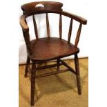 A late Victorian ash smokers bow armchair, the crest with a hand grip, the arms on ring turned