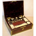 An early nineteenth century rosewood veneered dressing case, with brass banding and stringing, the