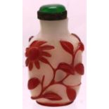 A Chinese carved Peking glass scent bottle, with red overlay floral decoration, a green stone