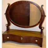 A nineteenth century Sheraton Revival mahogany oval swing toilet mirror, the frame with stringing,