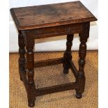 A seventeenth century oak joined stool, the moulded edge seat on a chip carved frieze baluster,