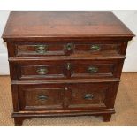 An oak chest of low proportion, with three long drawers, the panelled fronts with replaced oval