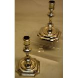 A pair of George I cast silver candlesticks, the baluster stems with urn shape candle holders, on