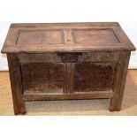 A small early seventeenth century oak coffer, the double panelled hinged lid and front with