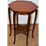 An Edwardian mahogany lamp table, the circular top with a serpentine edge and shaped friezes, on