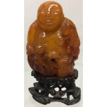 A nineteenth century amber carving of Budai Ho Shang, the monk with the hempen bag, with two