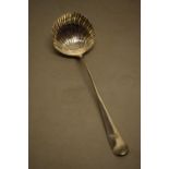 A George II hanoverian pattern silver soup ladle, with a hedgehog crest shell fluted bowl, (an old
