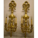 A pair of carved giltwood Neo Classical wall sconces, the ribbon tied floret blocks with rams head