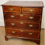 An early eighteenth century oak chest of two short and three long drawers, with walnut cross