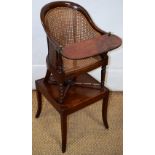 A Victorian mahogany child's caned bergere chair with a foot rest, on front turned legs, the