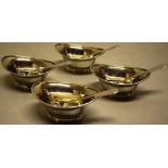 A set of four George III oval silver navette shape salts, gilded inside and engraved a crest on a