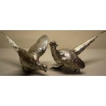 A pair of cast silver ornamental cock and hen pheasants, with garnet eyes, 9in (23cm) Makers