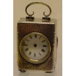 An Edwardian hammered silver case boudoir timepiece, the movement dial missing a hand, with a