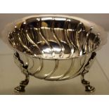 A late Victorian silver sweetmeat bowl in Irish style, swirl fluted with a shaped rim, on three