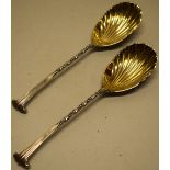 A pair of late victorian onslow pattern silver fruit servers, with beaded twist handles and gilded