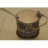 A silver drum shape mustard pot, the pierced fretwork sides with repousse laurel swags linking