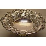 A late Victorian circular silver fruit bowl, the repousse grapevine and floral scroll hatched border