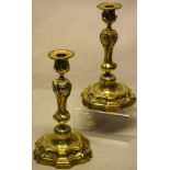 A pair of French cast ormolu candlesticks, in Louis XV rococo style, with chased decoration with