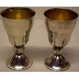 A pair of Swiss hammered silver coloured metal .800 standard goblets, the inverted pear shape bowls,