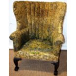 A gentleman's wing armchair, the ribbed barrel shape upholstered back, to a sprung seat, covered