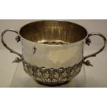 A Charles II silver porringer, with acanthus repousse decoration, two cast scroll handles on a