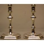 A pair of early George II silver tapersticks, the spool shaped holders on knopped silesian stems,