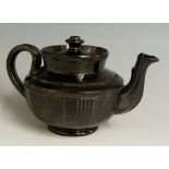 A black glazed pottery teapot of compressed globular form with basket moulded body and geometric