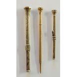 Three Victorian gold coloured metal pencils, one foliate engraved with entwined serpent,