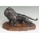 A Japanese bronze lion, realistically modelled, glass eyes, 27cm long,