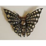 A gold coloured metal diamond set butterfly brooch the head and body with rough cut brilliants