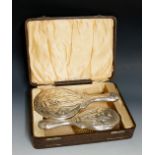 An Edwardian Art Nouveau silver dressing table set, comprising hair brush and hand mirror,