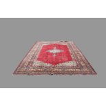 A Persian style carpet, the crimson field with central medallion, the spandrels floral filled,