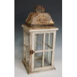 A decorative embossed white metal and glazed wooden lantern with cylindrical cowl and splayed top